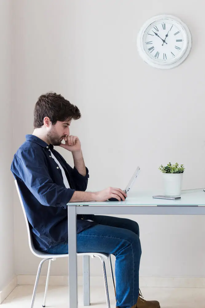 Hombre que usa computadora portatil mientras piensa