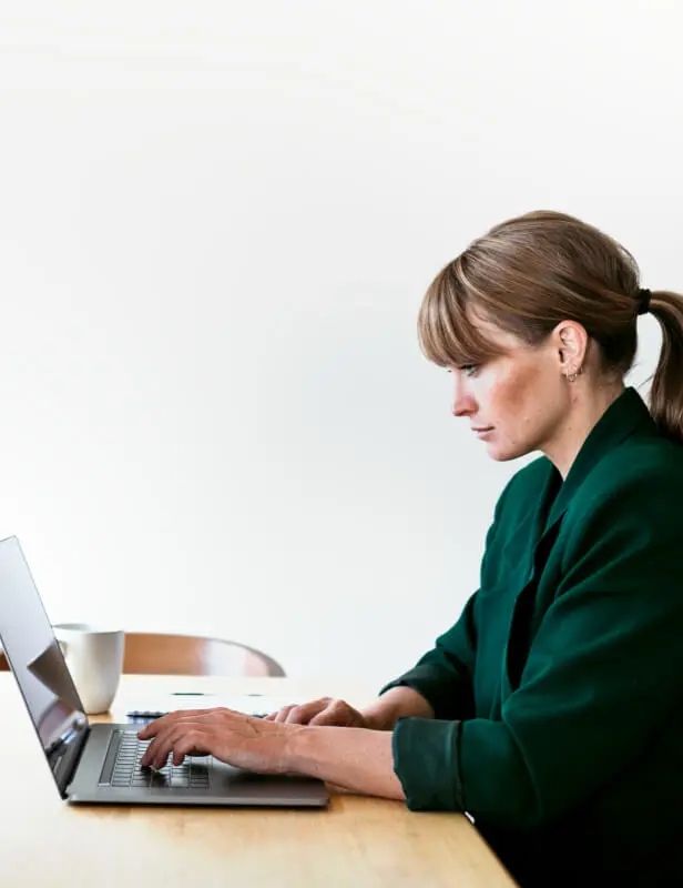 Mujer escribiendo en su laptop sentada